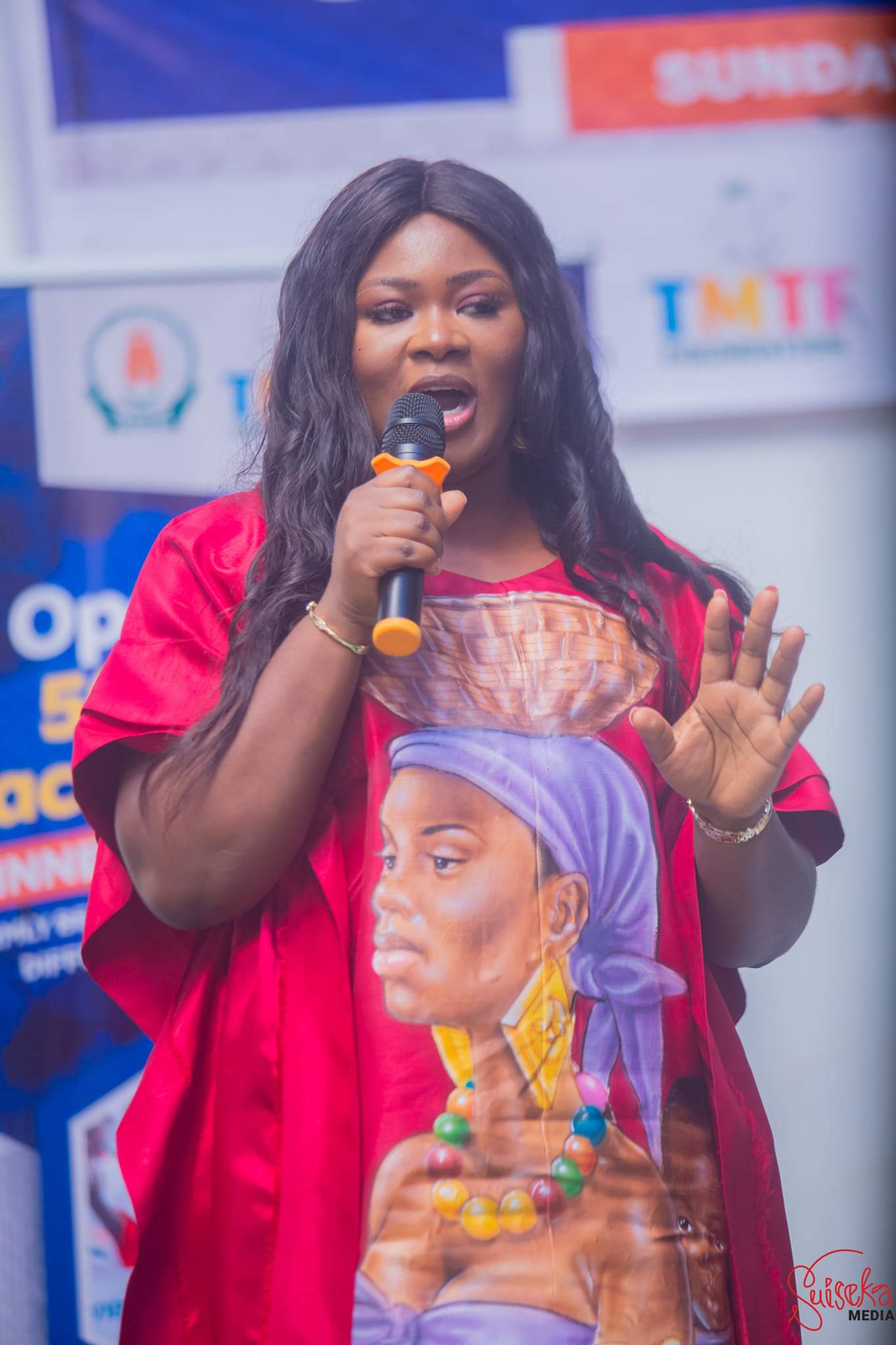 TMTF founder Dorothy Akoh-Arrey speaking into a microphone at a Back to School event